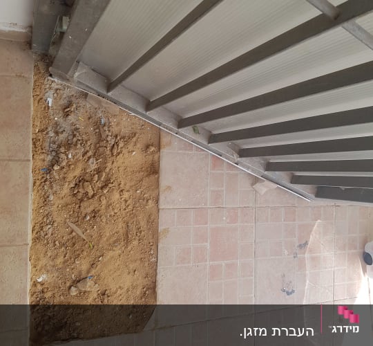 אזור חפור ברצפה ליד קיר מתכת
